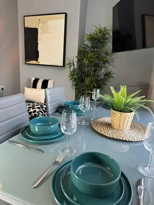 a table with green plates and wine glasses on it at Ideal Wigan Base - 1BR for Cosy Stays in Wigan