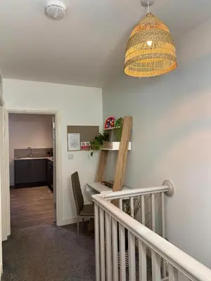 a room with a staircase with a table and a light at Ideal Wigan Base - 1BR for Cosy Stays in Wigan