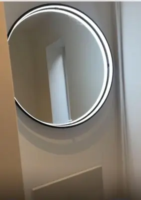 a round mirror on the door of a bathroom at blackburn home in Blackburn