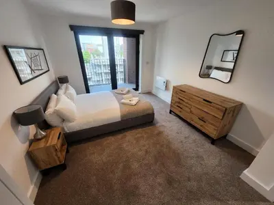 a bedroom with a bed and a large mirror at Modern & Bright 2 Bedroom Apartment in Liverpool in Liverpool