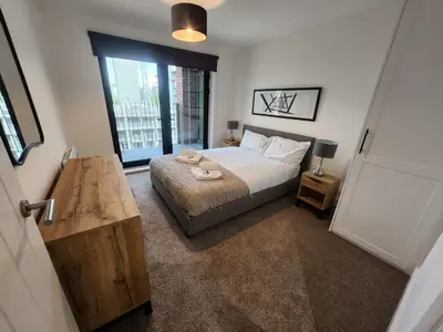 a bedroom with a bed and a large window at Modern & Bright 2 Bedroom Apartment in Liverpool in Liverpool