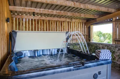 a bath tub with a shower in a house at Ivy Cottage in Silverdale