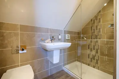 a bathroom with a sink and a toilet and a shower at Ivy Cottage in Silverdale