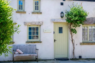 a building with a bench and a yellow door at Ivy Cottage in Silverdale