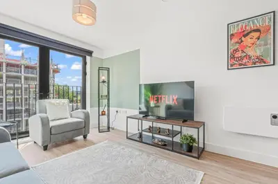 a living room with a tv and a chair at The Vintara Suite - Central - 2Bed - Cozy Stay in Liverpool