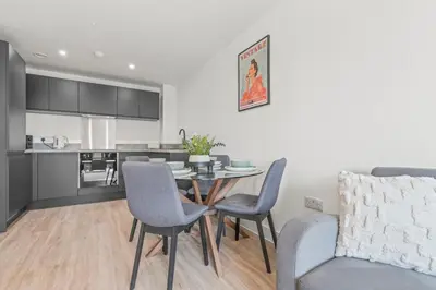a living room with a table and chairs and a kitchen at The Vintara Suite - Central - 2Bed - Cozy Stay in Liverpool