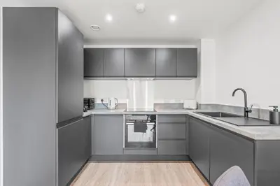 a kitchen with gray cabinets and a sink at The Vintara Suite - Central - 2Bed - Cozy Stay in Liverpool