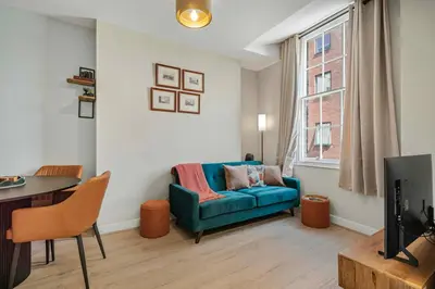 a living room with a blue couch and a table at GuestReady - Stylish getaway in Liverpool in Liverpool