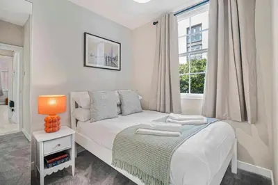 a white bedroom with a bed and a window at GuestReady - Stylish getaway in Liverpool in Liverpool