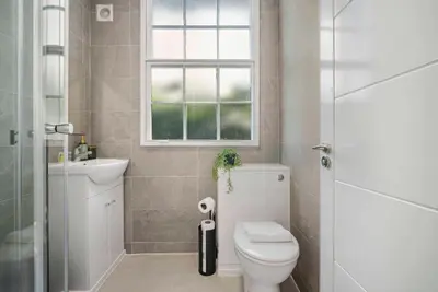 a bathroom with a toilet and a sink and a window at GuestReady - Stylish getaway in Liverpool in Liverpool