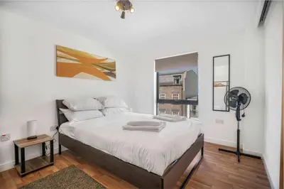 a bedroom with a large bed and a fan at GuestReady - Modern stay in Liverpool city centre in Liverpool