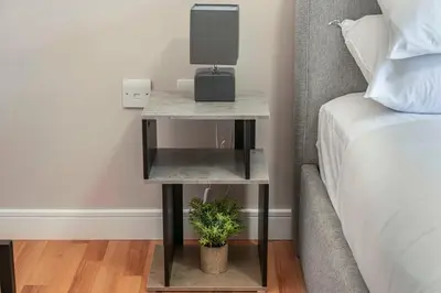 a side table with a speaker on it next to a bed at GuestReady - Modern stay in Liverpool city centre in Liverpool