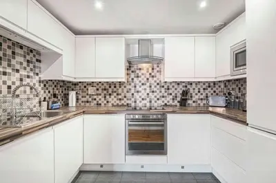 a white kitchen with white cabinets and a sink at GuestReady - Modern stay in Liverpool city centre in Liverpool