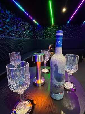 a table with wine glasses and a bottle on it at New - The Fun House Blackpool - Private nightclub in Blackpool