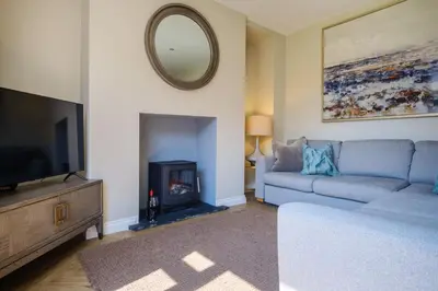 a living room with a couch and a tv and a mirror at The Bank House in Silverdale