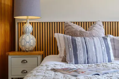 a bedroom with a bed with a lamp on a night stand at The Bank House in Silverdale