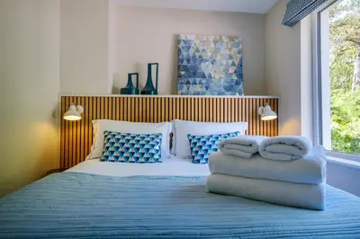 a bedroom with a bed with blue and white pillows at The Bank House in Silverdale
