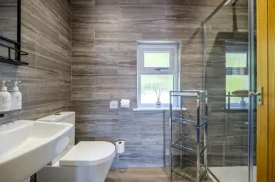 a bathroom with a toilet and a glass shower at The Bank House in Silverdale