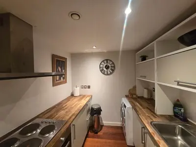 a kitchen with a sink and a clock on the wall at Ventro Apartments LIVERPOOL in Liverpool