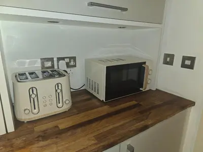 a microwave and a toaster oven sitting on a counter at Ventro Apartments LIVERPOOL in Liverpool