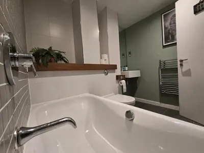 a bathroom with a white tub and a toilet at Ventro Apartments LIVERPOOL in Liverpool