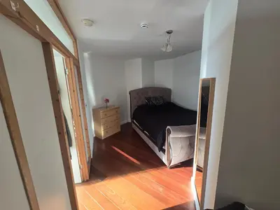 a small bedroom with a bed and a wooden floor at Ventro Apartments LIVERPOOL in Liverpool