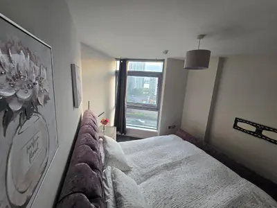 a bedroom with a bed and a large window at Ventro Apartments LIVERPOOL in Liverpool