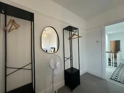 a room with a fan and a mirror on the wall at Your Home in Southport! in Southport