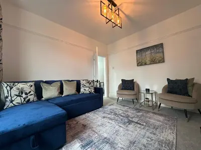 a living room with a blue couch and two chairs at Your Home in Southport! in Southport