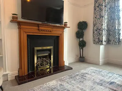 a living room with a fireplace with a television above it at Your Home in Southport! in Southport
