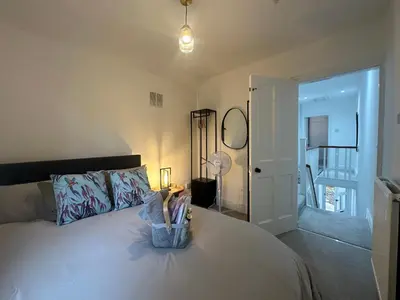 a bedroom with a bed with a lamp and a mirror at Your Home in Southport! in Southport