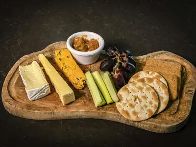 a wooden plate with cheese and vegetables and bread at Pullman Liverpool in Liverpool