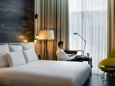a man sitting at a desk with a laptop in a hotel room at Pullman Liverpool in Liverpool