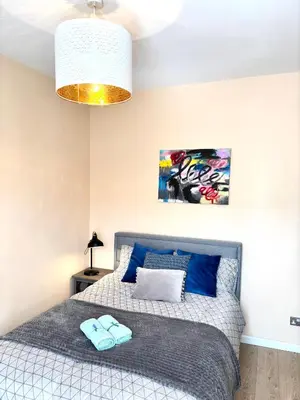 a bedroom with a bed with blue pillows on it at Modern Art House - serviced accomodation in Liverpool