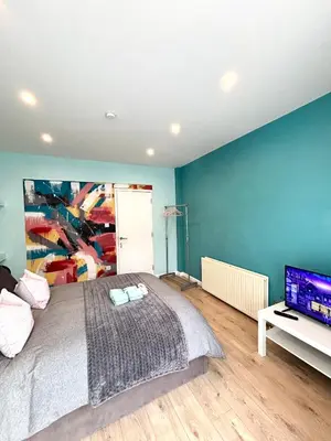 a bedroom with a bed and a flat screen tv at Modern Art House - serviced accomodation in Liverpool
