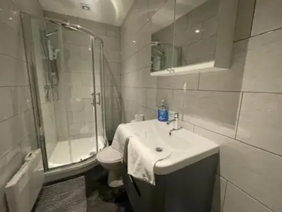 a bathroom with a sink and a shower and a toilet at Bond Street Apartment Near the Promenade with Two Bathrooms and Workspace in Blackpool