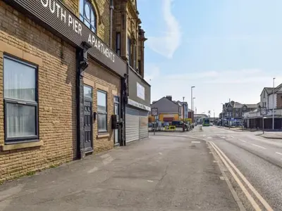 an empty street next to a brick building at Bond Street Apartment Near the Promenade with Two Bathrooms and Workspace in Blackpool