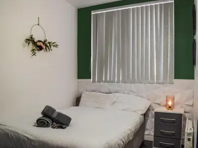 a room with a bed with a camera and a window at Bond Street Apartment Near the Promenade with Two Bathrooms and Workspace in Blackpool