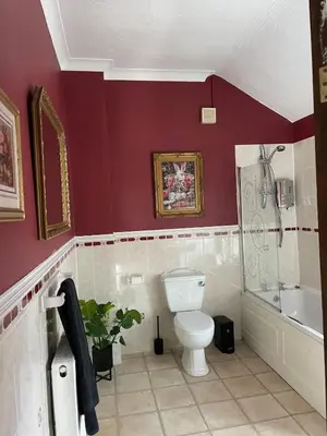 a bathroom with red walls and a toilet and a tub at Alices House in Fleetwood