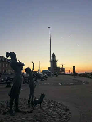 a statue of a woman and two children and a dog at Alices House in Fleetwood