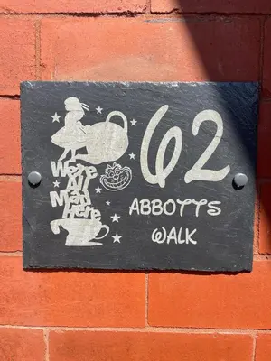 a sign on the side of a brick wall at Alices House in Fleetwood
