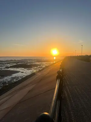 a sunset on the beach with the sun setting over the ocean at Seaside Getaway - Lytham Road in Warton