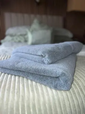 a pile of towels sitting on top of a bed at Seaside Getaway - Lytham Road in Warton
