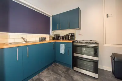 a kitchen with blue cabinets and a stove at Swindon Home in Liverpool