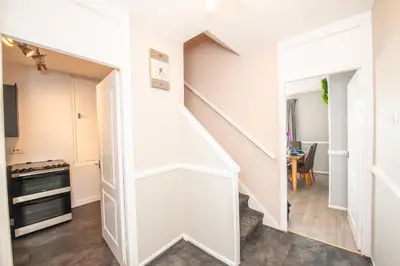 a white staircase in a living room with a table at Swindon Home in Liverpool
