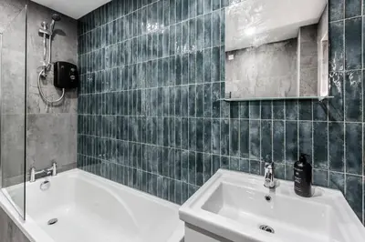 a bathroom with a sink and a tub and a mirror at Waterfront 2 Bed Apartment - Free Parking & Wi-Fi in Preston