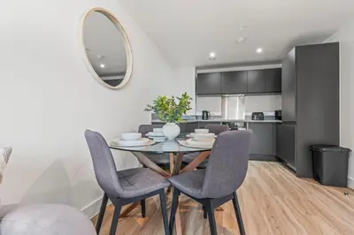 a dining room with a table and chairs and a kitchen at Elegance Suite 2Bed 2BR Contractors Central in Liverpool
