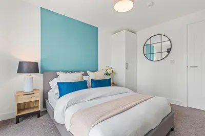 a bedroom with a large bed with blue accents at Elegance Suite 2Bed 2BR Contractors Central in Liverpool
