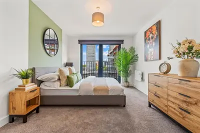 a bedroom with a large bed and a dresser at Elegance Suite 2Bed 2BR Contractors Central in Liverpool