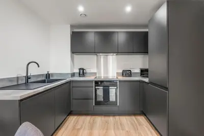 a kitchen with gray cabinets and a sink at Elegance Suite 2Bed 2BR Contractors Central in Liverpool